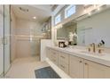 Modern bathroom featuring dual sinks, a glass shower, and stylish gold fixtures at 9425 Villa Ridge Dr, Las Vegas, NV 89134