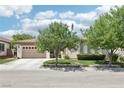 Inviting single-story home showcasing mature trees and a pristine lawn, offering a serene street view at 10404 Stanberry Ave, Las Vegas, NV 89135