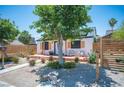 Front exterior featuring desert landscaping, modern fencing, and seating area on the charming porch at 108 Verdy Ln, Las Vegas, NV 89101