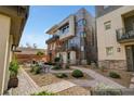 Modern townhome with desert landscaping, paved walkways, and a shared outdoor seating area at 10985 Limeslice Ave # 2, Las Vegas, NV 89135