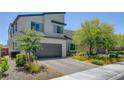 Modern home showcasing a two-car garage, contemporary architecture, and desert-friendly landscaping at 1321 Hudson Creek Pl, North Las Vegas, NV 89084
