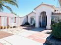 Charming single-story home with stone pathway leading to front door, desert landscaping, and an arched entryway at 1860 Banaba Ln, Las Vegas, NV 89156