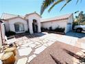 Charming single-story home with stone pathway leading to front door, desert landscaping, and an arched entryway at 1860 Banaba Ln, Las Vegas, NV 89156
