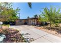 Cozy home featuring a long driveway and stone accents, enhanced by mature trees and landscaping at 201 Cervantes St, Las Vegas, NV 89101