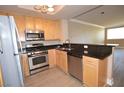 Eat-in kitchen with stainless steel appliances, stone countertops, wood cabinetry, and light wood floors at 220 E Flamingo Rd # 116, Las Vegas, NV 89169