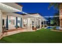 Covered patio with outdoor dining and seating area, overlooking a well-manicured lawn and sparkling pool at 2231 S Tioga Way, Las Vegas, NV 89117