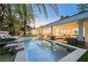 Stunning backyard pool with covered patio, lounge area, and elegant outdoor seating for entertaining or relaxing at 2231 S Tioga Way, Las Vegas, NV 89117