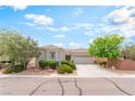 Charming single-story home featuring desert landscaping and a two-car garage at 2413 Mourning Warbler Ave, North Las Vegas, NV 89084