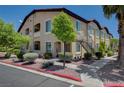 Tan two-story condo building with stairs, drought resistant landscaping, and a sidewalk at 3320 Cactus Shadow St # 201, Las Vegas, NV 89129