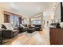 Spacious living room featuring hardwood floors, a large window, and comfortable seating arrangements, ideal for relaxation at 3473 Conough Ln, Las Vegas, NV 89129
