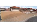 Single-story house with a two-car garage and a wide driveway; desert landscaping and terracotta roof tiles at 411 Monmouth Ct, Henderson, NV 89015