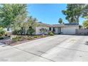 This single-story home has mature vegetation and an extra wide driveway leading to the garage at 4445 Peterson Dr, Las Vegas, NV 89103