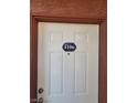 A close view of a white front door with dark brown trim and a unit number plaque at 4730 E Craig Rd # 1106, Las Vegas, NV 89115