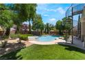 A spacious backyard features a sparkling pool, spa, and lush greenery, creating a tranquil retreat at 5186 San Milano Ave, Las Vegas, NV 89141