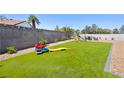 Spacious backyard with artificial grass, perfect for play, and framed by a concrete block wall with gravel features at 6017 Montecito Way, Las Vegas, NV 89108