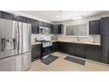 Modern kitchen with stainless steel appliances, dark cabinetry, wood countertops, and a subway tile backsplash at 6017 Montecito Way, Las Vegas, NV 89108