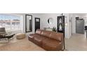 Bright living room featuring a comfortable brown leather sofa, a large window, and contemporary decor at 6017 Montecito Way, Las Vegas, NV 89108