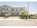 Charming two-story townhome featuring a neutral color palette and manicured landscaping at 7002 Fossil Rim St, North Las Vegas, NV 89084