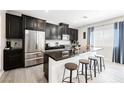 Modern kitchen with stainless steel appliances, a spacious island, and sleek black cabinetry at 7002 Fossil Rim St, North Las Vegas, NV 89084