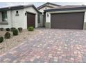 A well-maintained exterior of a single-story home with a three-car garage and desert landscaping at 7265 Southern Magnolia St, Las Vegas, NV 89149