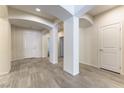 Bright foyer with neutral walls, gray tile floors, arched entryways, and a white front door at 7265 Southern Magnolia St, Las Vegas, NV 89149