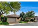 Attractive single-story home with a tile roof, two-car garage, and mature trees, showcasing curb appeal at 9921 Mirada Dr, Las Vegas, NV 89144