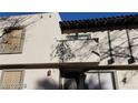 Two story residential building with neutral stucco exterior with dark trim, a balcony, front door, and small front yard at 1336 N Jones Blvd, Las Vegas, NV 89108