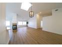 Bright and airy living room boasts vaulted ceilings, wood-look flooring, fireplace, and modern light fixture at 1519 Deerford Cir, Las Vegas, NV 89110