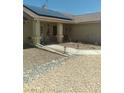 Charming home featuring a front porch, desert landscaping, and solar panels on the roof at 1611 Red Rock Dr, Pahrump, NV 89048
