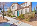 Charming two-story home with manicured landscaping and a unique turquoise front door at 2037 Brush Stroke St, Henderson, NV 89044