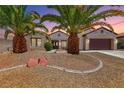 Attractive single-story home with desert landscaping and a two-car garage featuring a pair of palm trees at 2114 Twin Falls Dr, Henderson, NV 89044