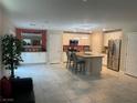 Open kitchen with stainless steel appliances, an island with seating, and tile flooring at 330 Silva Pl, Henderson, NV 89011