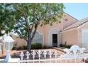 Charming home exterior with decorative fence, lush landscaping, and a well-maintained front yard at 3519 W Red Coach Ave, North Las Vegas, NV 89031