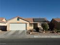 Charming single-story home with a two-car garage, desert landscaping, and roof-mounted solar panels at 4636 Ferrell St, North Las Vegas, NV 89031