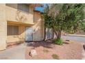 Inviting townhome showcasing tan stucco, a secure entrance, and drought-resistant landscaping at 499 Kristin Ln, Henderson, NV 89011