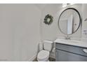 Clean half-bath featuring a round mirror, updated vanity, and modern fixtures at 625 Honesty Ct, Henderson, NV 89011