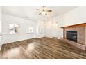 Spacious living room boasts wood floors, a cozy fireplace, and natural light from large windows at 654 Mazelle Ln, Pahrump, NV 89060