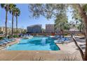 Enjoy the community pool with ample seating and clear blue water on a sunny day at 7609 Trimming Ct, Las Vegas, NV 89149