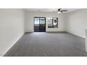 Spacious living room featuring neutral walls, carpet floors, and sliding glass doors at 7873 Running Doe Ct, Las Vegas, NV 89149