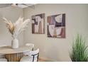 Dining room with a modern, round wood table, stylish chairs, elegant floral arrangement, and contemporary artwork at 8000 Badura Ave # 1007, Las Vegas, NV 89113