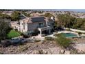 A view of the home's backyard, featuring a pool, patio area, and well-maintained landscaping at 9301 Queen Charlotte Dr, Las Vegas, NV 89145