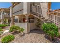 Charming condo exterior featuring textured walls, gated patios, and convenient stairs to the upper-level units at 1017 Falconhead Ln # 101, Las Vegas, NV 89128