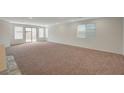 Spacious living room with neutral carpet, recessed lighting, and large windows providing ample natural light at 10198 Eden Mountain St, Las Vegas, NV 89141