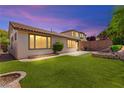 Beautiful backyard featuring a lush lawn, an outdoor seating area, and attractive landscaping at 11764 Golden Moments Ave, Las Vegas, NV 89138