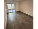 Bright living room with modern gray vinyl flooring and a sliding glass door at 12170 Midnight Pine Rd # 3, Las Vegas, NV 89183