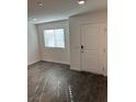Bright living room with gray vinyl flooring, a window, and a white front door at 12170 Midnight Pine Rd # 3, Las Vegas, NV 89183