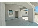 Covered front entrance with an elegant front door and attractive arched windows at 1580 S Tiptop Trl, Pahrump, NV 89048