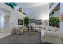 Bright living room with high ceilings, carpet flooring, and ample natural light from windows at 2437 Desert Butte Dr, Las Vegas, NV 89134