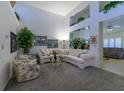 Bright living room with high ceilings, carpet flooring, and ample natural light from windows at 2437 Desert Butte Dr, Las Vegas, NV 89134