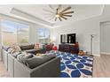 Bright living room with a large sectional sofa, patterned rug, and a modern ceiling fan at 245 Hull St, Henderson, NV 89015